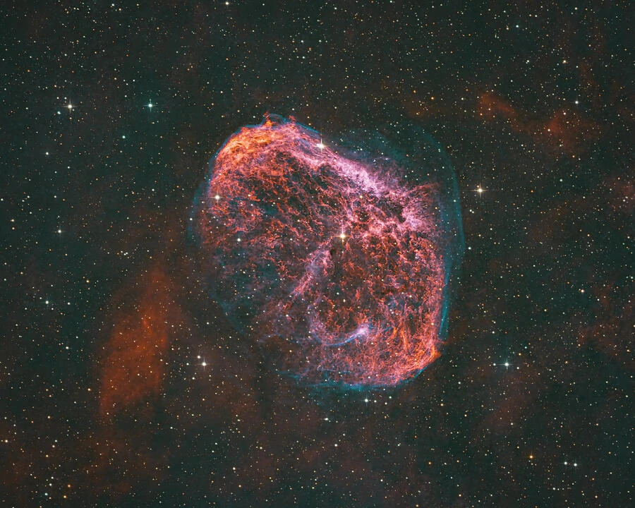 The Crescent Nebula, a curved shell of luminous gas set among the stars.